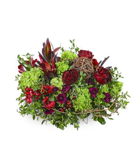 The Ruby Hour flower arrangement with deep red roses, hydrangea, mums, alstroemeria, Safari Sunset, and rustic vine accents in a modern vase.